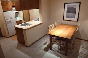 Enjoy a simple and functional kitchen with a refrigerator, stove, and dining area.