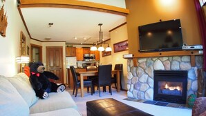 Una sala de estar acogedora con chimenea, televisor y comedor.