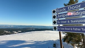 A signpost with directions to various locations including Back Door, Juniper Ridge, Chief & Sunnyside, and Toilet Bowl & Father Tom.