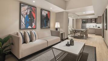 A modern living room with a sofa, coffee table, and abstract art on the wall.