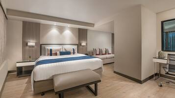 Una habitación de hotel moderna con una cama grande, un escritorio y una silla, además de un ventanal.