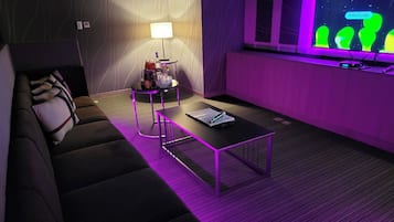 Una sala de estar moderna con un sofá, una mesita de centro y una pantalla de televisión que muestra 'Interlude'.