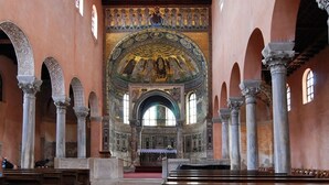 Un interior con techos altos, columnas en arco y un mosaico central.