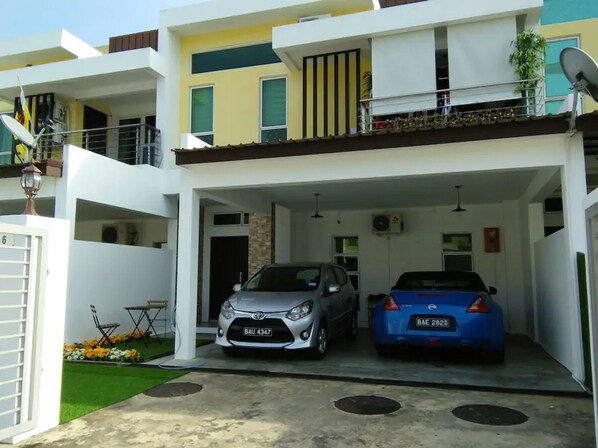 A modern two-story residential building with a covered parking area. - Co. Living Suite (Bandar Seri Begawan)