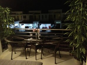 A balcony with a table and chairs, surrounded by potted plants. - Co. Living Suite (Bandar Seri Begawan)