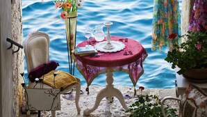 A seaside view with a table set for two, a chair, and a lamp. - Studio apartment in Rovinj with Seaview, Terrace, Air condition, WIFI (4686-6) (Rovinj)