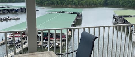 Enjoy a serene lake view from this balcony, perfect for dining or relaxation, with a table and two chairs.