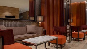 A modern hotel lobby with a sofa, armchairs, a coffee table, and a mirror. - MPALACE HOTEL KUALA LUMPUR (Kuala Lumpur)