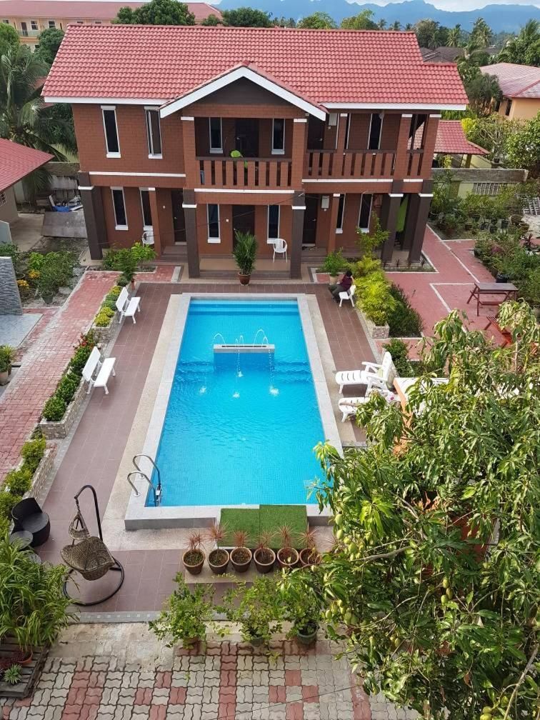 A two-story building with a swimming pool in the foreground.