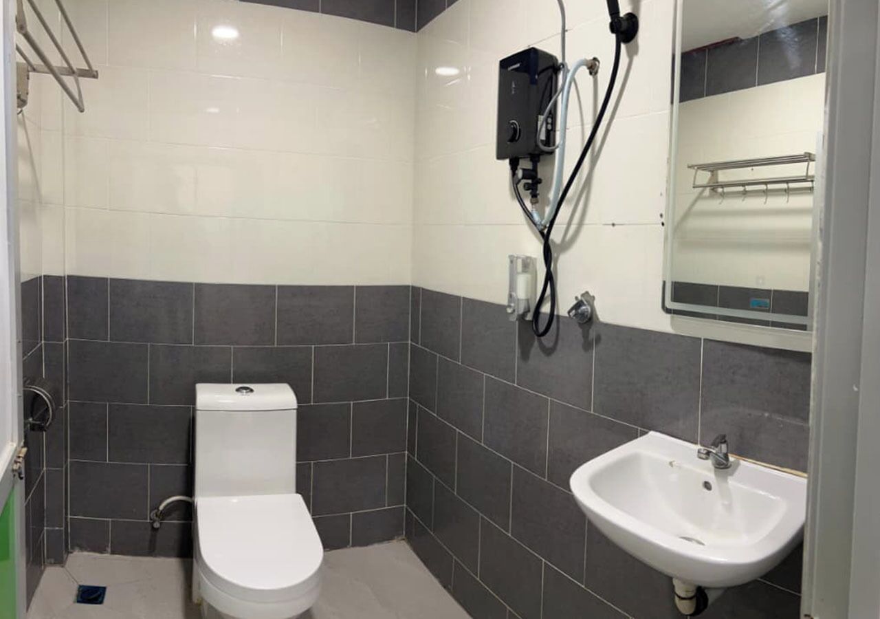 A small bathroom with a toilet, sink, and shower.