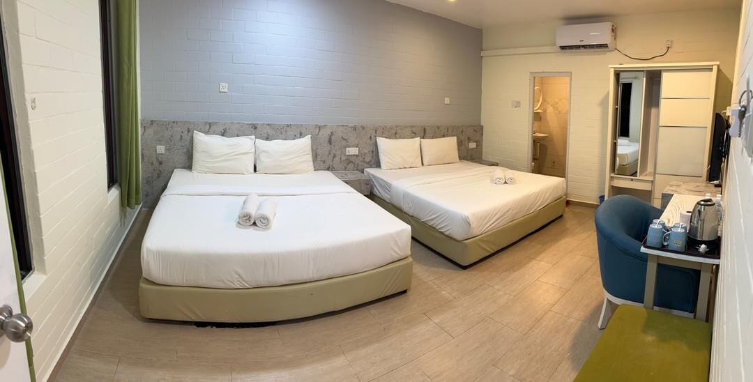 Une chambre d’hôtel avec deux lits, un bureau avec une chaise et un miroir.