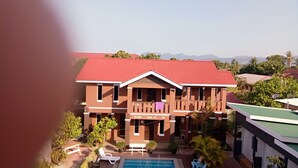 A two-story building with a red roof, a balcony with a purple towel, and a swimming pool in the foreground. - D'Lima Beach Inn (Langkawi)