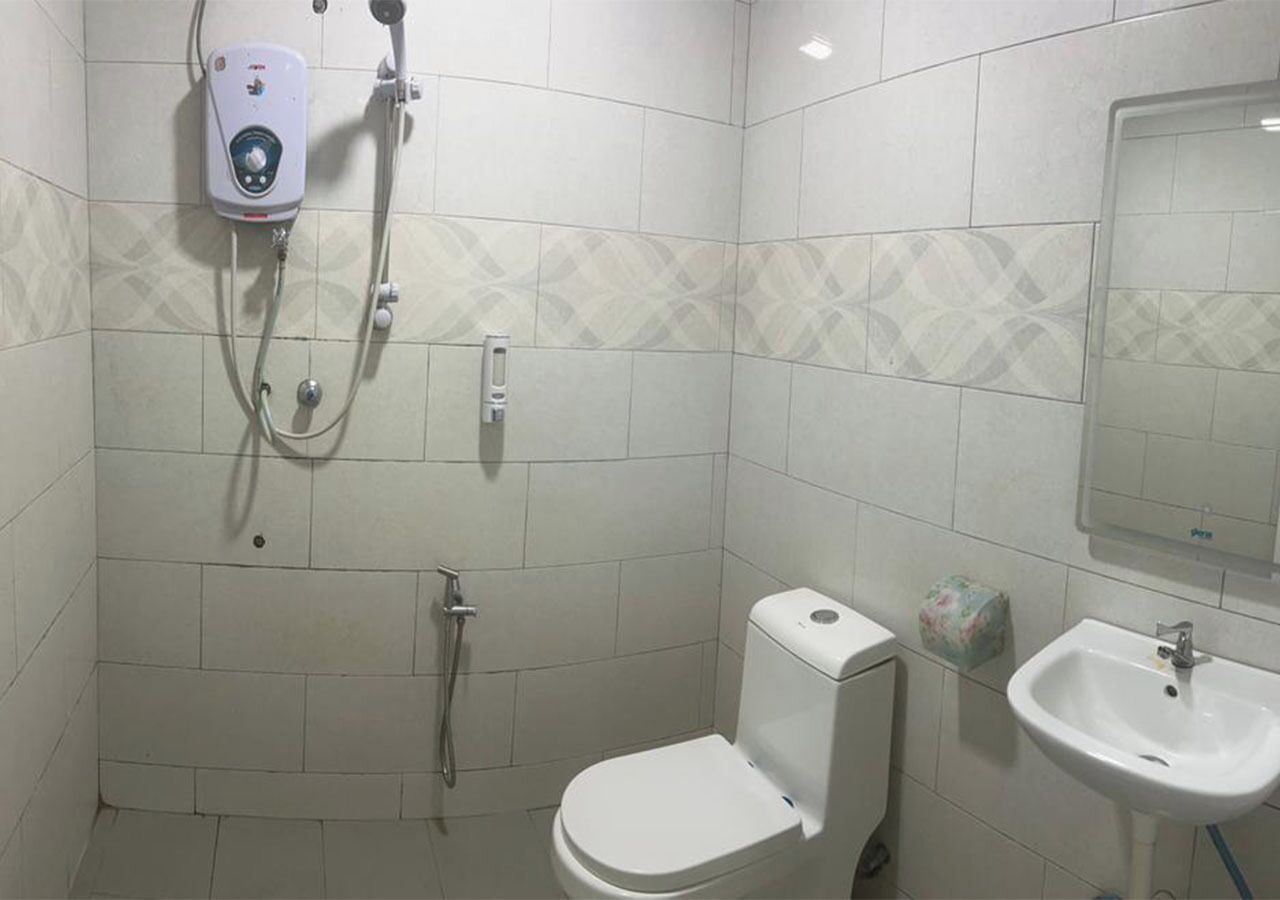 A bathroom with a toilet, a sink, and a shower unit.