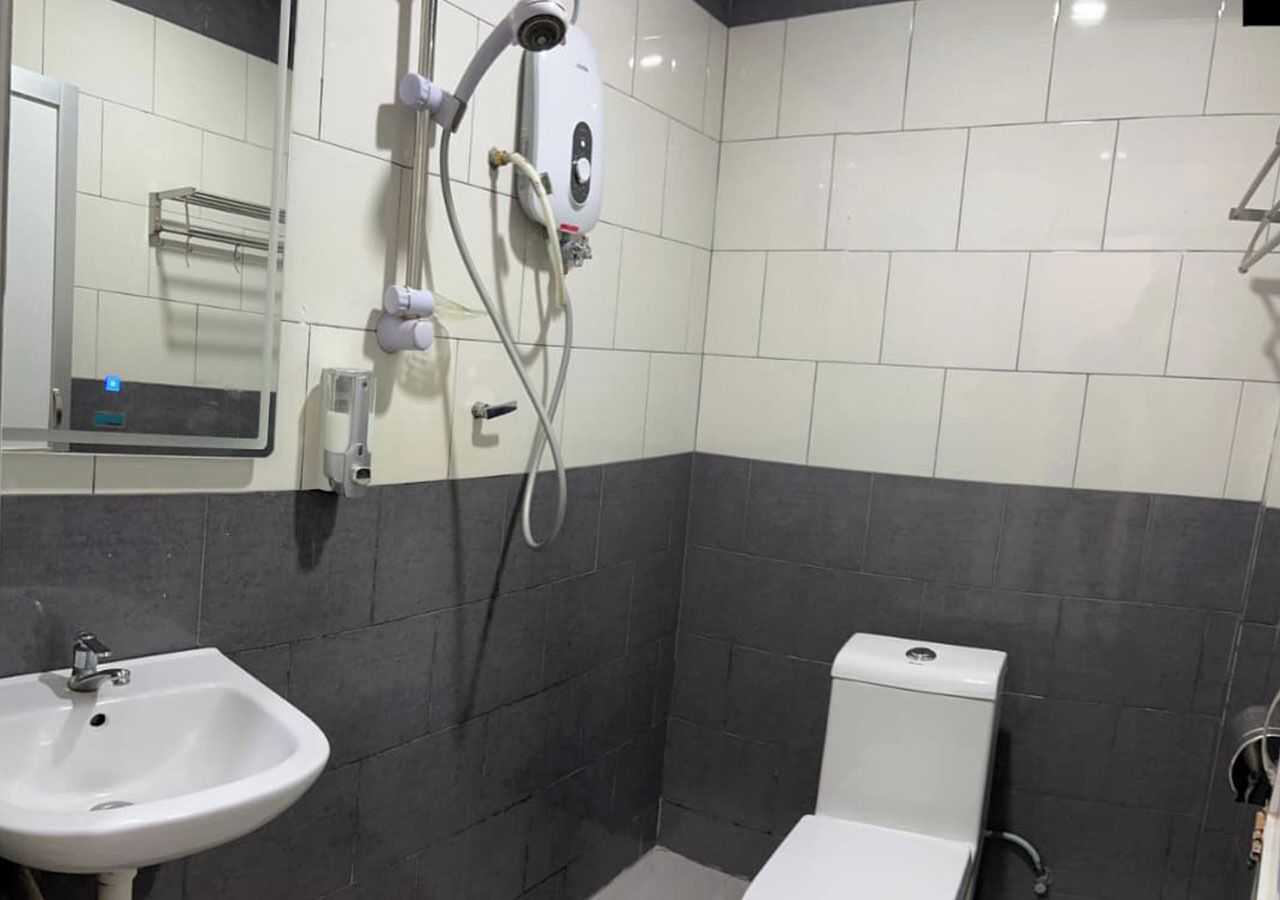 A bathroom with a white sink, a toilet, and a shower area.
