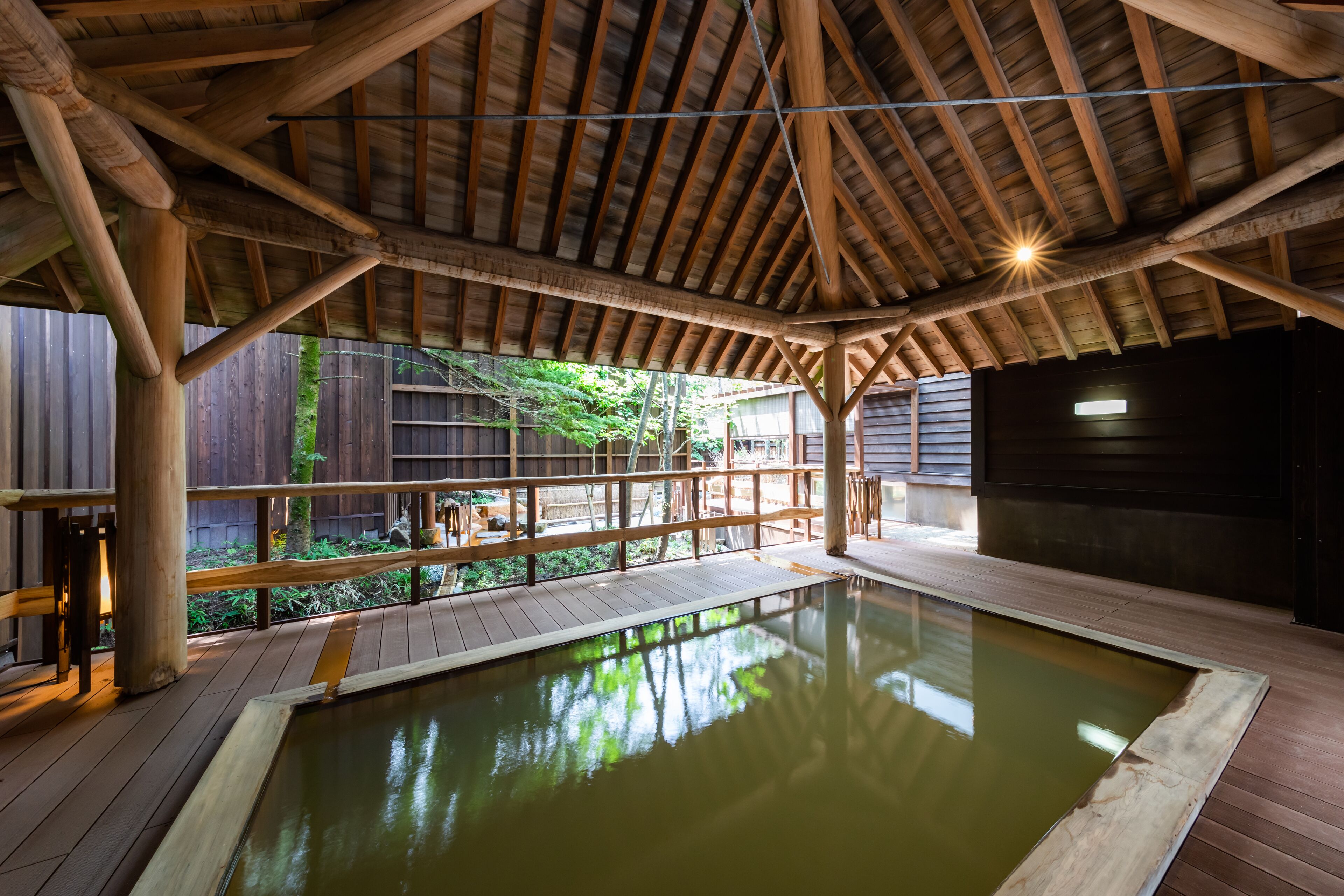 Ein Pool mit Holzterrasse, Holzbalken und Geländer.