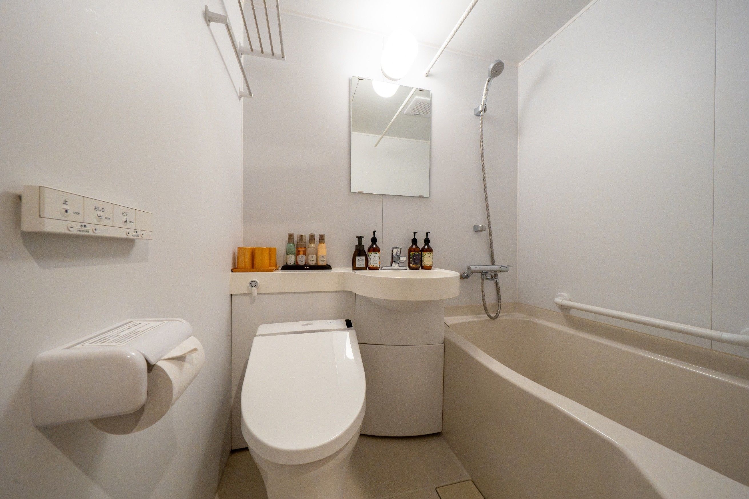 A modern bathroom with a toilet, sink, and bathtub.
