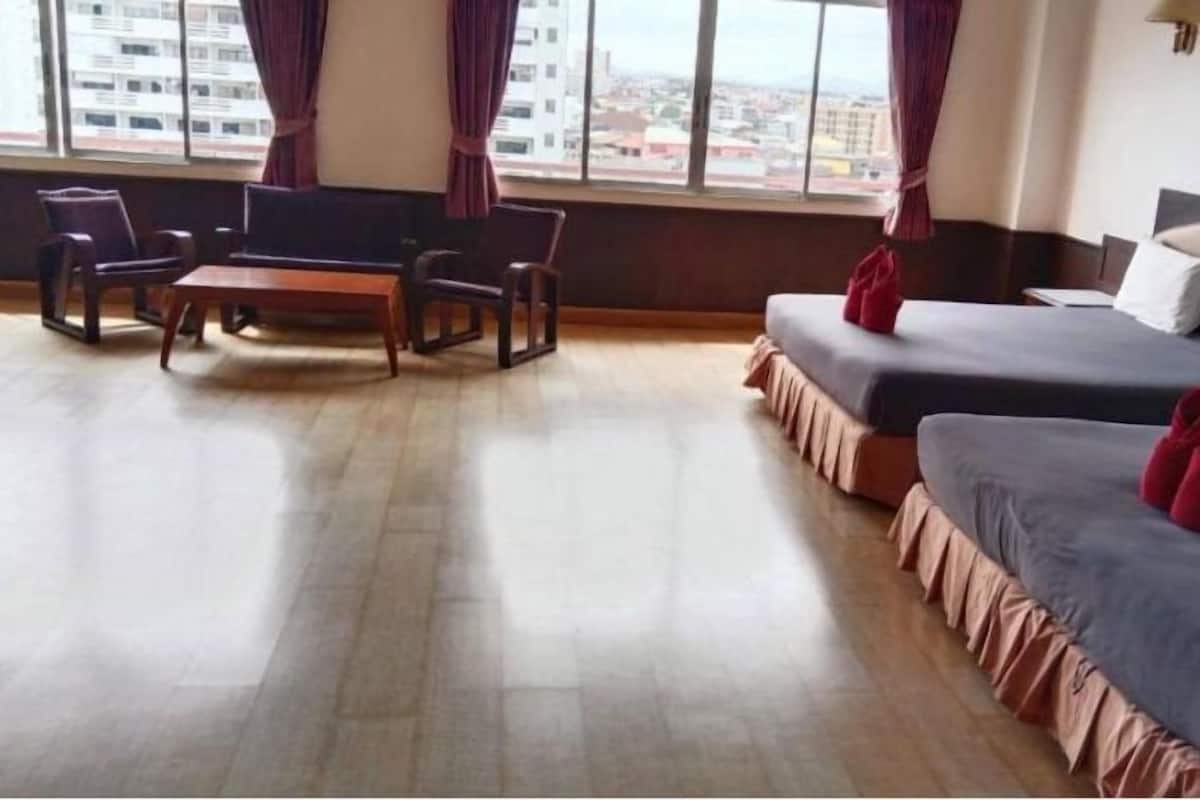 Ein Hotelzimmer mit zwei Betten, einem kleinen Tisch und Stühlen.