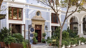 A hotel with a classic facade, a central entrance, and multiple potted plants around the entrance area. - Labotessa Luxury Boutique Hotel (Cape Town)