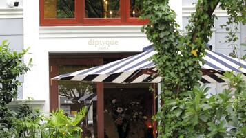 A building with a sign reading "diptyque paris" and a striped awning.