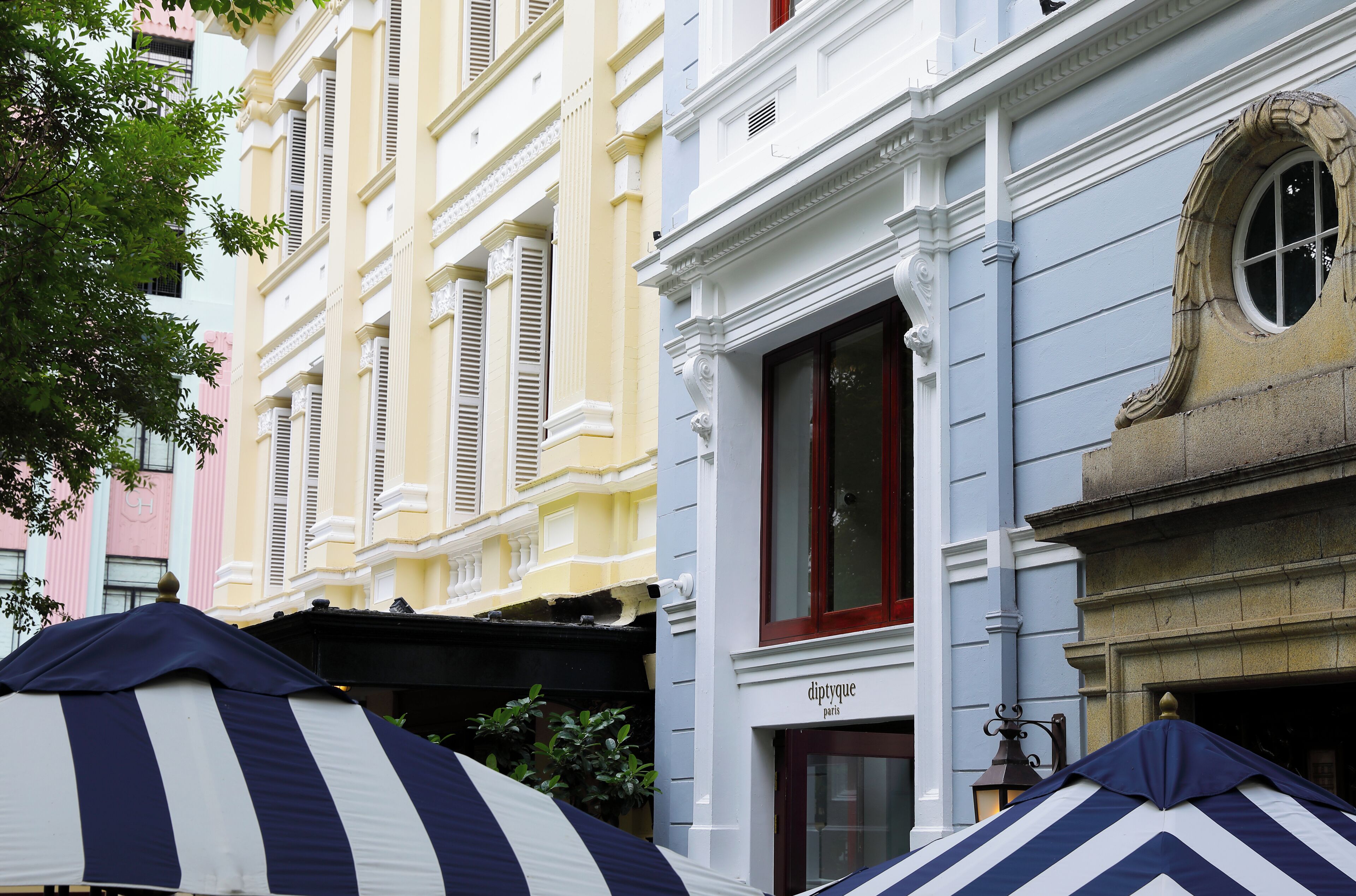 A row of colorful buildings with a shop named 'diptyque' on the ground floor.