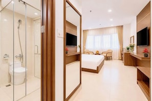 A hotel room with a shower, toilet, bed, TV, and a desk with a chair. - T78 Hotel (Ho Chi Minh City)
