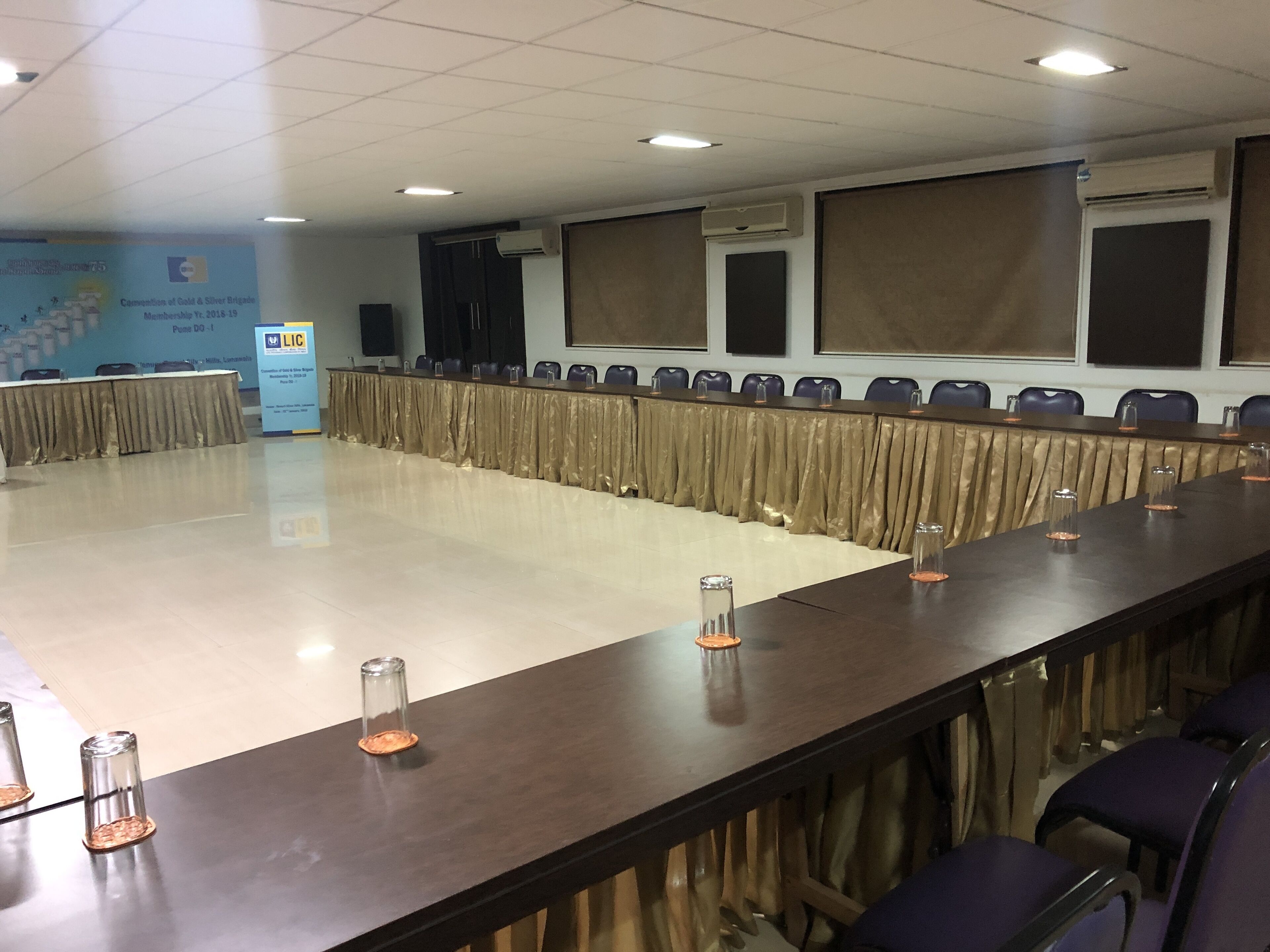 A conference room with a long table, chairs, and a podium.