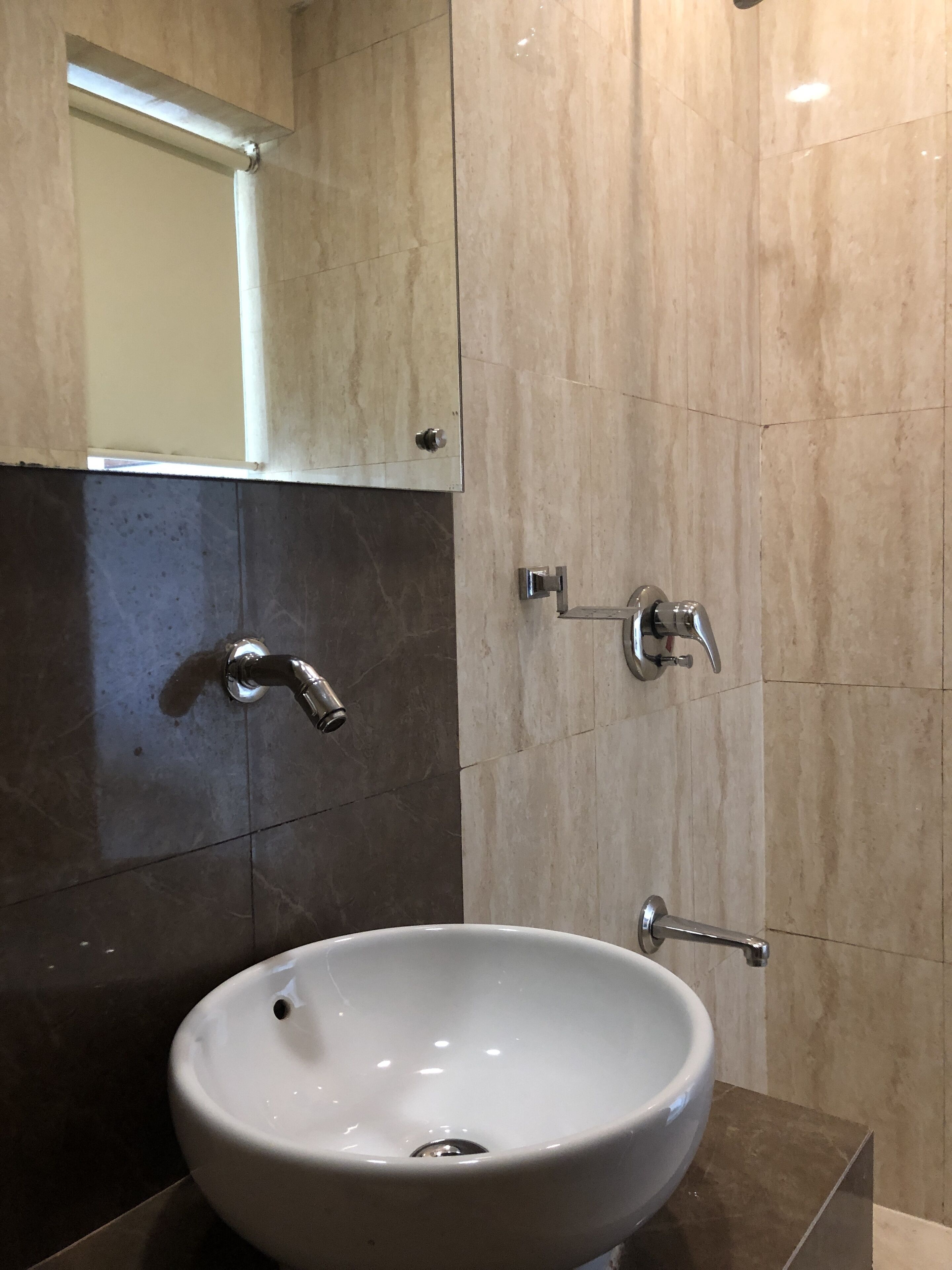Un baño con lavamanos blanco, espejo y ducha.