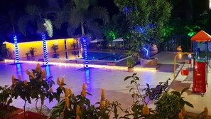 A well-lit outdoor area with a pool, seating, and potted plants. - Resort Silver Hills Lonavala (Mawal)