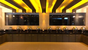 Una cocina moderna con una encimera amplia, varios electrodomésticos y un ventanal grande.
