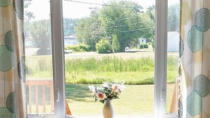 Una ventana con vista a un campo y árboles.