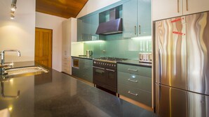 Une cuisine moderne équipée d’un réfrigérateur en acier inoxydable, d’un four encastré et d’une cuisinière à gaz.