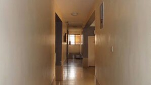 A narrow hallway with wooden flooring and beige walls. - Eliata Hotel & Suites (Lagos)