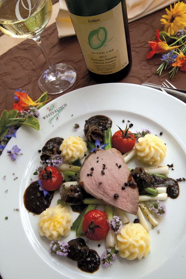 A plate of food with a bottle of wine and a glass of wine on a table.