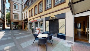 Straßenansicht mit einem Café, einem Boutique-Geschäft und einem geschlossenen Laden.