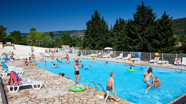A swimming pool area with multiple pools, lounge chairs, and umbrellas. - Ludocamping Mobil-Home (Lussas)