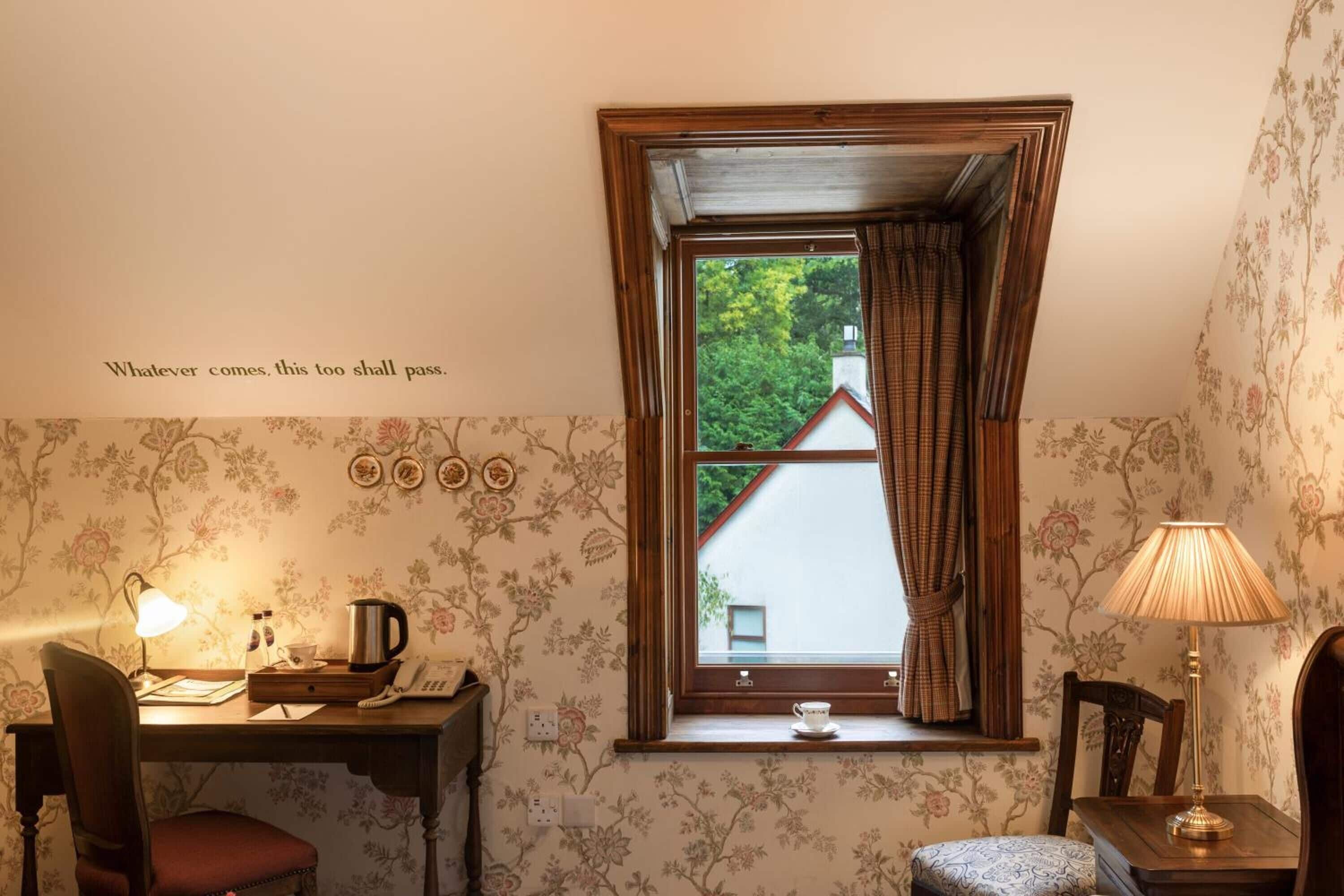 A cozy room with a desk, chair, and a window with curtains.