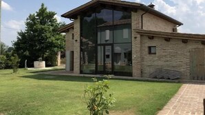 Een modern huis met een groot raam, een bakstenen gevel en een verzorgd gazon.