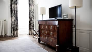 Une pièce comprenant une commode en bois, un téléviseur à écran plat, une lampe et un radiateur.