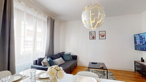 Un soggiorno moderno con un divano, un tavolo da pranzo e un'originale lampada a sfera.