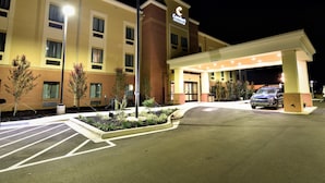 A hotel entrance with a canopy, a parking lot, and a flagpole. - Comfort Inn & Suites Rock Hill Northeast (Rock Hill)