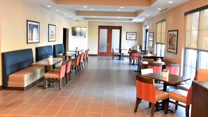 A spacious restaurant with high ceilings, multiple seating areas including booths and tables, and large windows providing natural light. - Comfort Inn & Suites Rock Hill Northeast (Rock Hill)