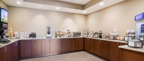A modern kitchen with a coffee station, a microwave, and a refrigerator.