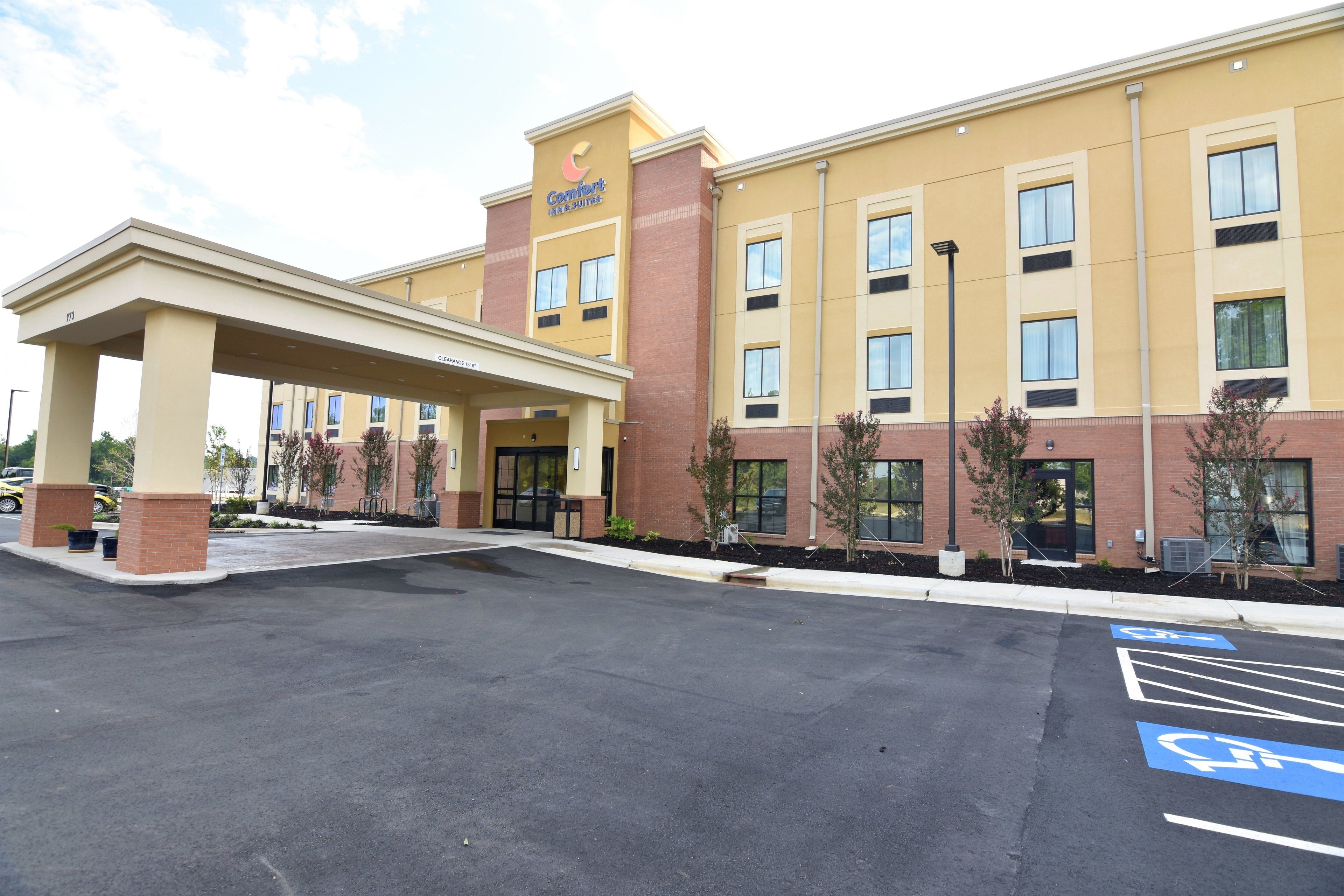 Un hotel Comfort Inn con entrada cubierta, aparcamiento y plazas reservadas para discapacitados, y fachada de ladrillo.