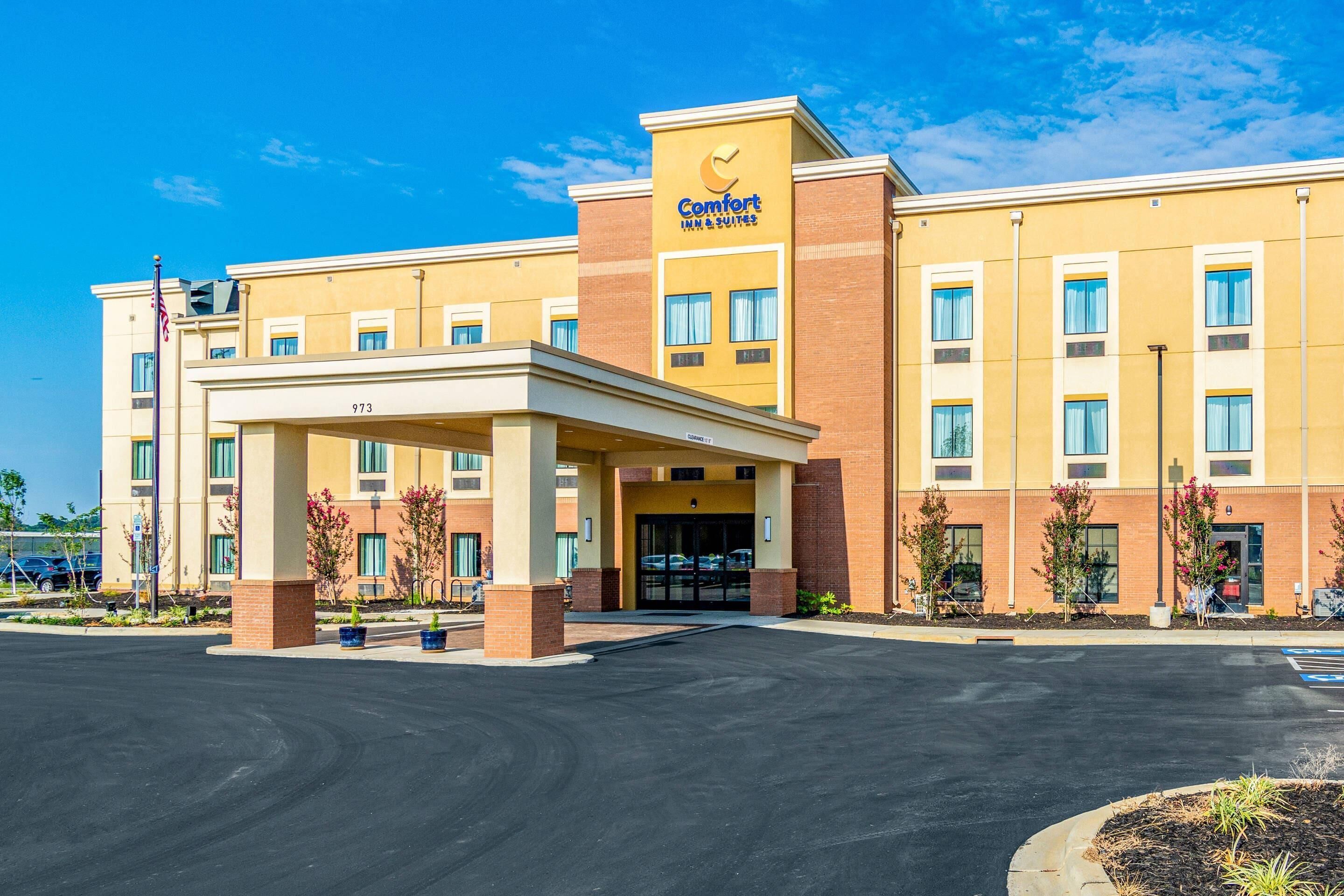 Un hotel Comfort Inn & Suites con entrada techada, varias ventanas y aparcamiento.