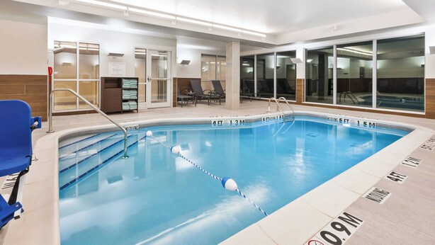 An indoor swimming pool with clear lane dividers, a diving board, and lounge chairs. - Fairfield Inn & Suites by Marriott Goshen (Goshen)