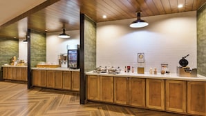 Une cuisine moderne avec des meubles en bois, un plan de travail blanc et un motif de parquet en chevrons.