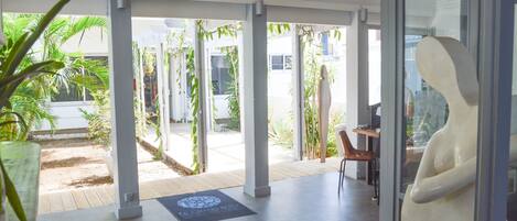 A modern indoor space with a glass wall, a sculpture, and a potted plant.