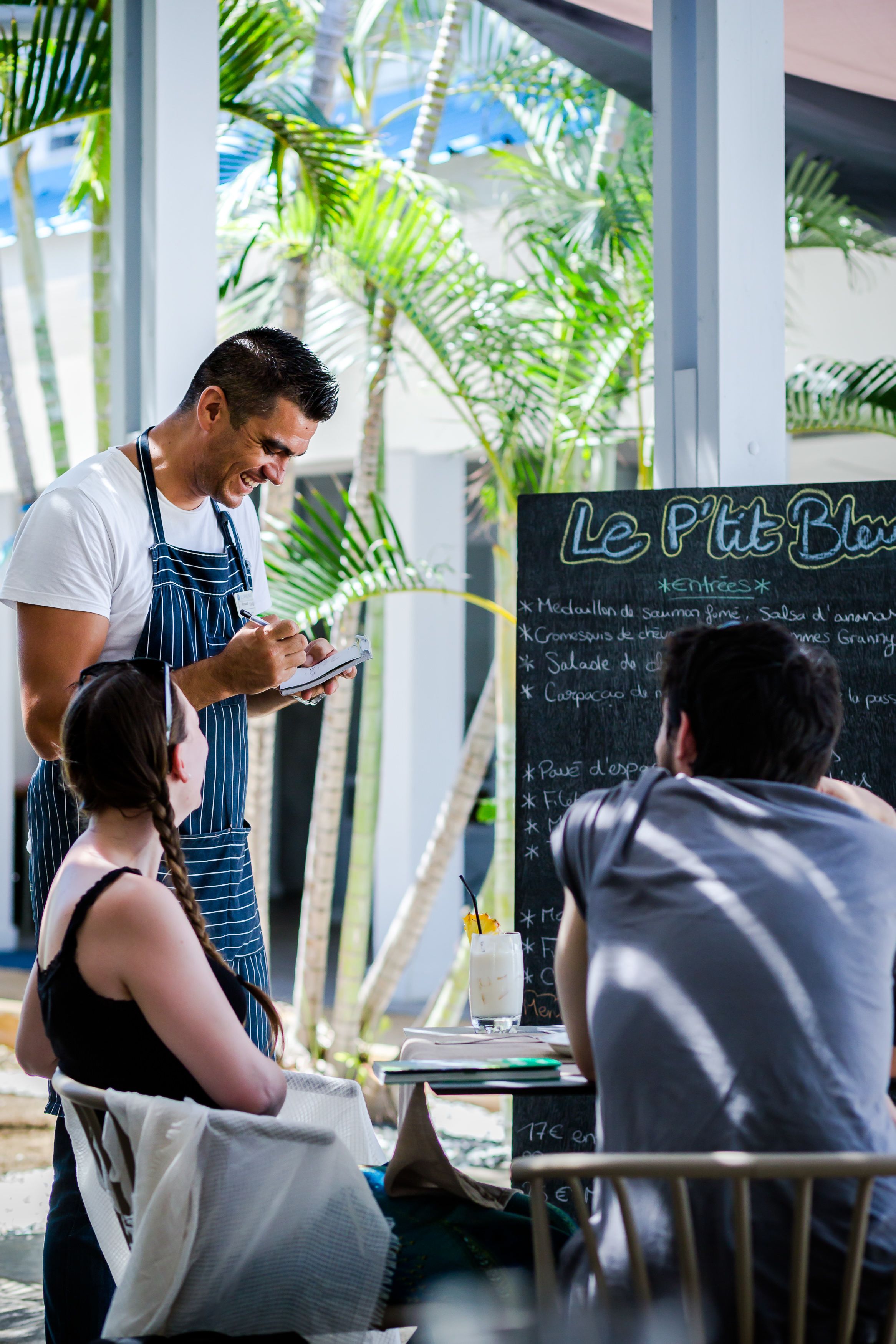 A cafe with a chalkboard menu listing various dishes.