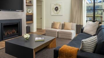 A modern living room with a fireplace, a sofa, a coffee table, and a TV.