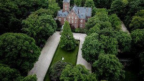 An aerial view of a large, historic building surrounded by dense greenery. - Kasteel de Wittenburg (Wassenaar)